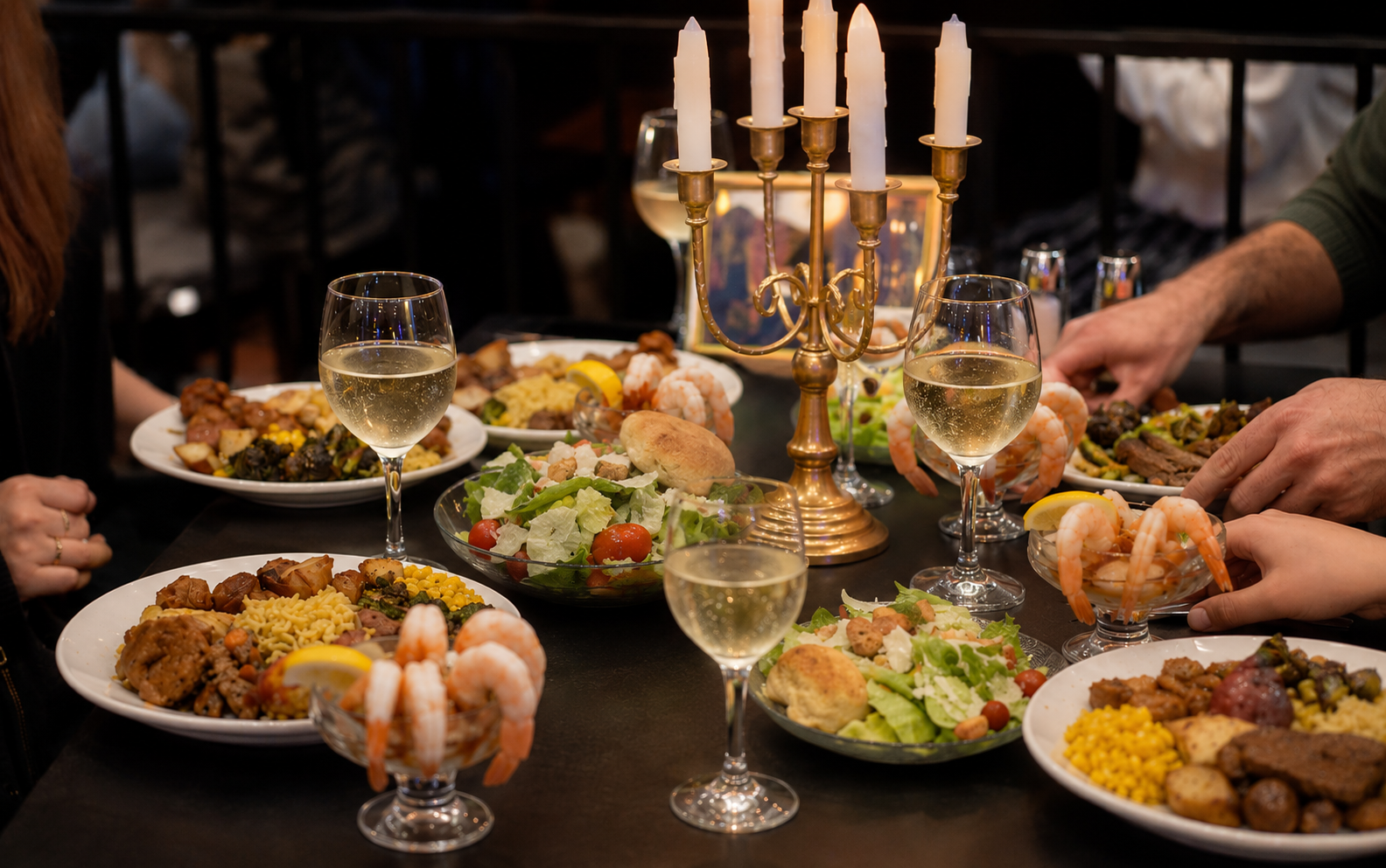 Dinner table with salads, shrimp cocktails, and wine glasses.