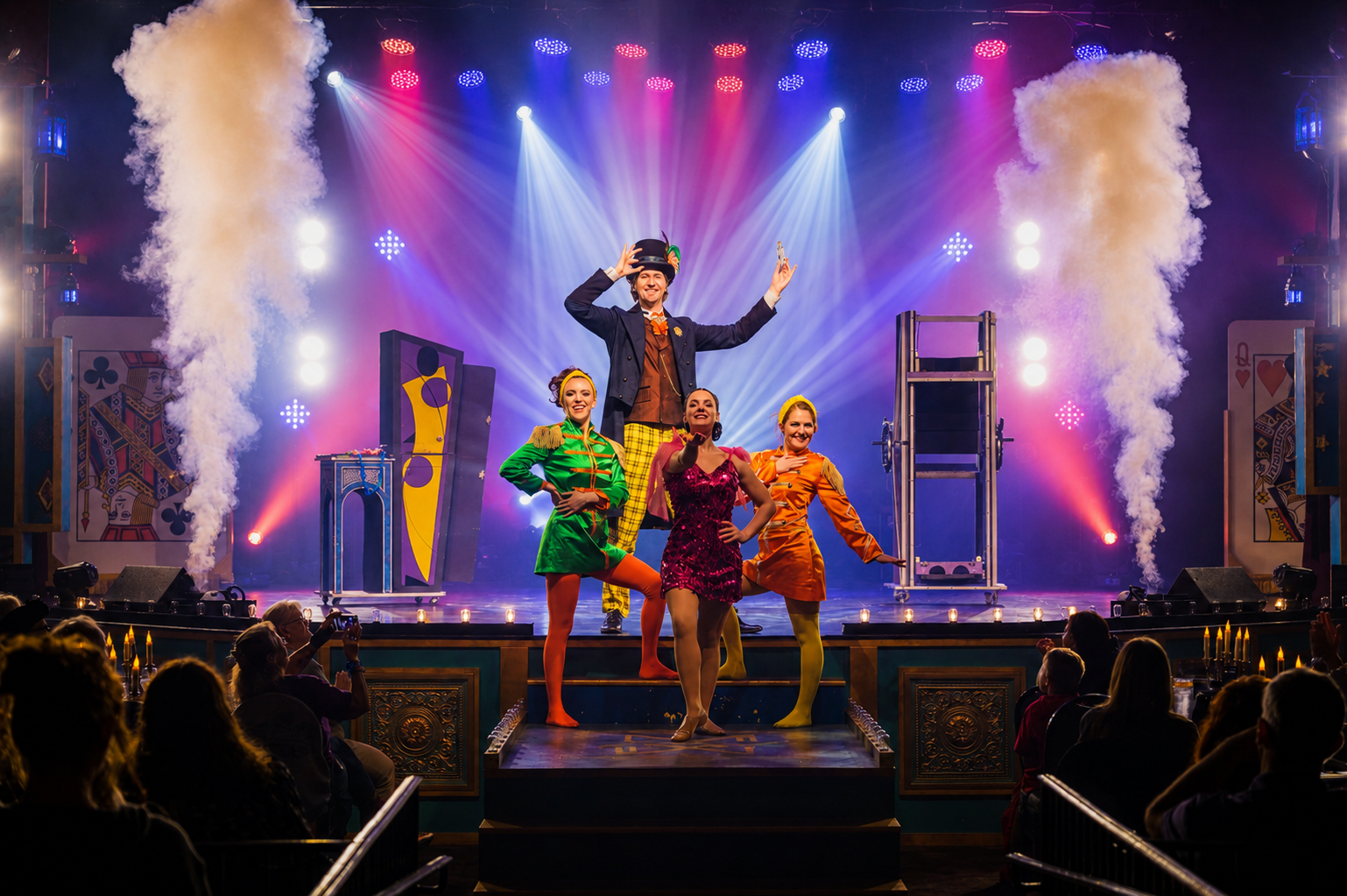 Colorful stage performance with four performers, bright lights, and smoke effects.