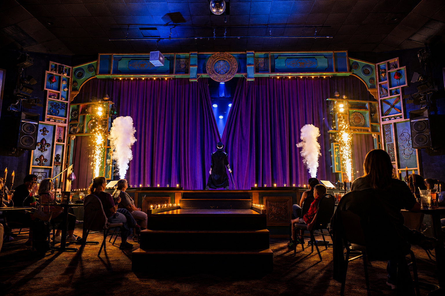 Dimly lit stage with purple curtains and audience seated in a theater setting.